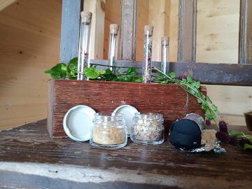 Selbstgemachte Naturprodukte aus Wildkräutern auf einem Holztisch bei einer Wildkräuterwanderung in der Steiermark